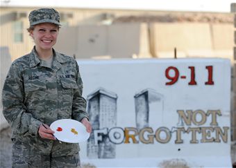SOUTHWEST ASIA – Senior Airman Adrianna Recine, 379th Expeditionary Medical Group laboratory technician, volunteers her time to refurbish the 9/11 barrier memorial here, March 21. Rising 6, a group dedicated to enlisted service members in the pay grades of E-1 through E-6, had adopted the memorial and asked for a volunteer to refurbish it. (U.S. Air Force photo/Senior Airman Joel Mease)