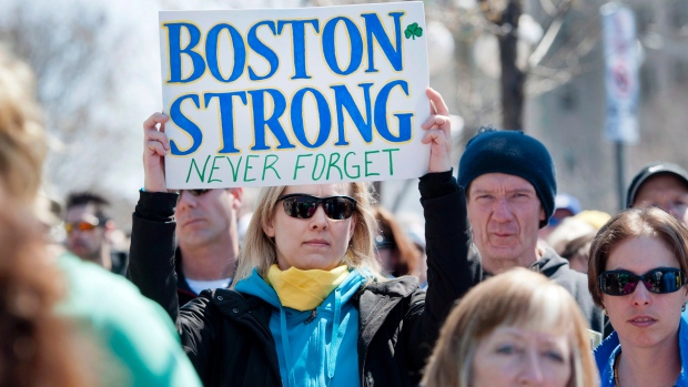 Ottawa runner Shelley Baran holds a sign in tribute to the Boston Marathon bombings at the US Embassy in Ottawa. (The Canadian Press/Justin Tang)