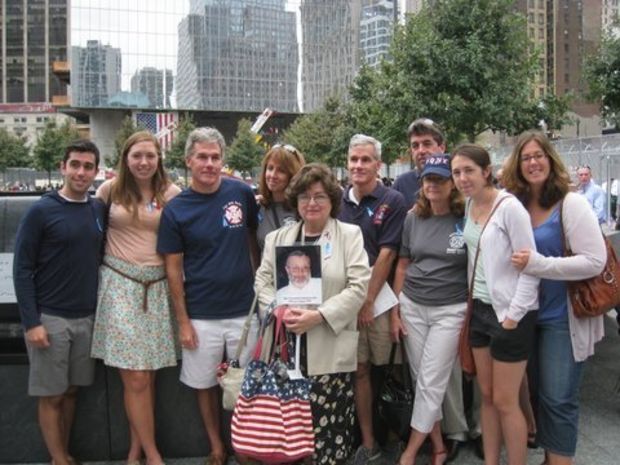 Chavie Zelmanowitz, center, with a photo of her brother-in-law Abe and members of the Burke family, in 2011, at one of the memorial pools, built on the footprints of the twin towers in memory of the September 11 attacks in New York City: Abe Zelmanowitz and Capt. Billy Burke were together with Abe's friend Ed Beyea, a paraplegic man in a wheelchair, when the towers fell on September 11, 2001. (Chavie Zelmanowitz | Submitted image)