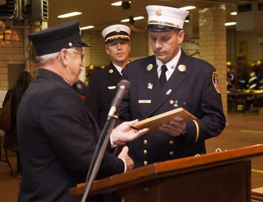 Battalion Chief Martin Ford (R), of the FDNY, accepts an award from Butch Brees in a dedication ceremony held for a memorial at the Haddonfield fire station in memory of the victims of 9/11