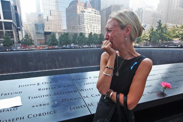 Carrie Bergonia of Pennsylvania looks over the name of her fiance, firefighter Joseph Ogren, at the 9/11 Memorial during ceremonies marking the 12th anniversary of the 9/11 attacks on the WorldTradeCenter in New York. (September 11, 2013) Photo credit: AP