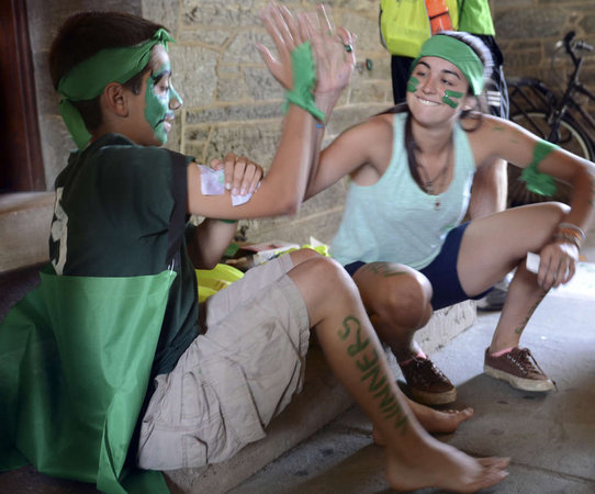 Ana Baena of Spain and Phil Garbarini of West Chester share a high-five as they finish applying body paint to represent the green team at the Peace Games. (Tom Gralish)