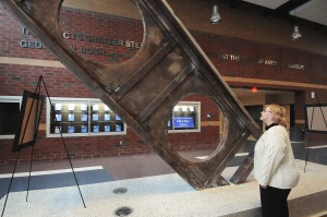Linda Shearer, founder of the Connellsville Area High School Patriots, stands next to a section of steel salvaged from the rubble of the North Tower of the World Trade Center in New York City. The steel, located in the auditorium lobby of the high school, is now a permanent memorial to the victims of the September 11, 2001, attacks. John F. Brothers | Herald-Standard