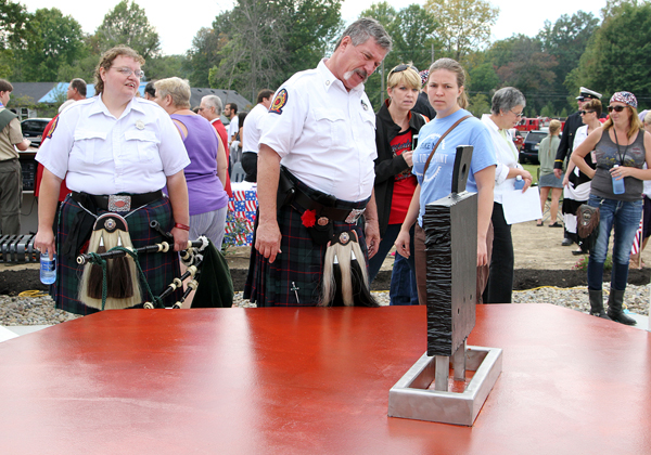 Cleveland Firefighters Memorial Pipe and Drum members view the steel from he World Trade Center  in the middle of the 9/11 Memorial after Sunday’s dedication ceremony. Anna Norris, Chronicle