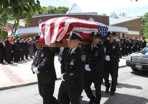 New York City police officers carry the flag-draped coffin of officer Nicholas Finelli out of Holy Rosary Church in Hawthorne after a funeral Mass Wednesday. Finelli doctors linked his cancer to the 9/11 attacks. Frank Becerra Jr. The Journal News