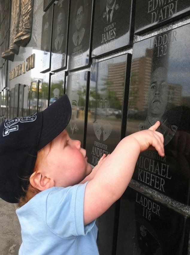 Jack Michael Foley points to image of his uncle, FF Michael Kiefer at Wall of Remembrance in Coney Island. Kiefer died on 9/11 — and  Jack’s middle name is Michael in his honor. 