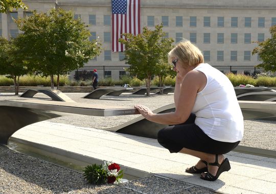 Joyce Johnson visits the marker dedicated to her husband Army Lt. Col. Dennis Johnson, who was killed in the 9/11 terrorist attack on the Pentagon. A huge flag marks the spot where a plane crashed into the Pentagon.(Photo: H. Darr Beiser, USA Today)