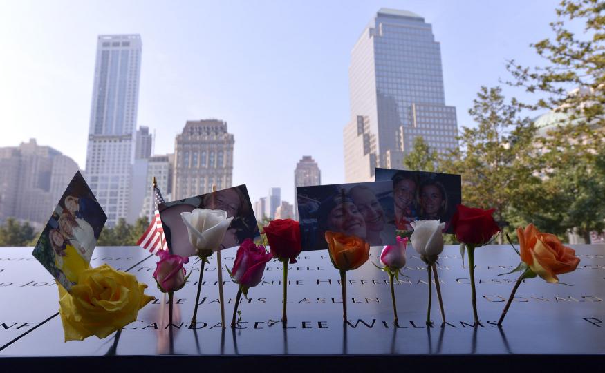 Flowers and pictures are placed along the North Pool at the 9/11 Memorial during a ceremony marking the 12th anniversary of the 9/11 attacks on the World Trade Center in New York, September 11, 2013. UPI/Justin Lane/Pool 