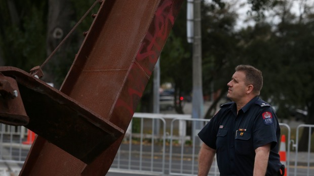 Christchurch central station officer Kelvin Hampton with the firefighters' memorial, which has been vandalised. Photo   Dean Kozanic