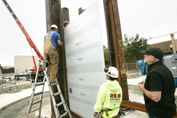  Artist Gordon Huether, right, watches as workmen secure one of four glass panels into position at the 9/11 Memorial in downtown Napa. The panels include the names of the victims killed in the attacks. J.L. Sousa/Register