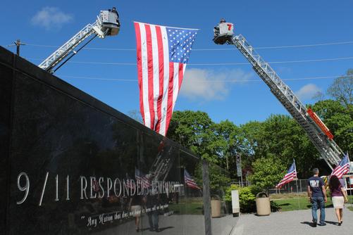Flag held aloft over Responders Remembered Memorial. photo Times of Smithtown