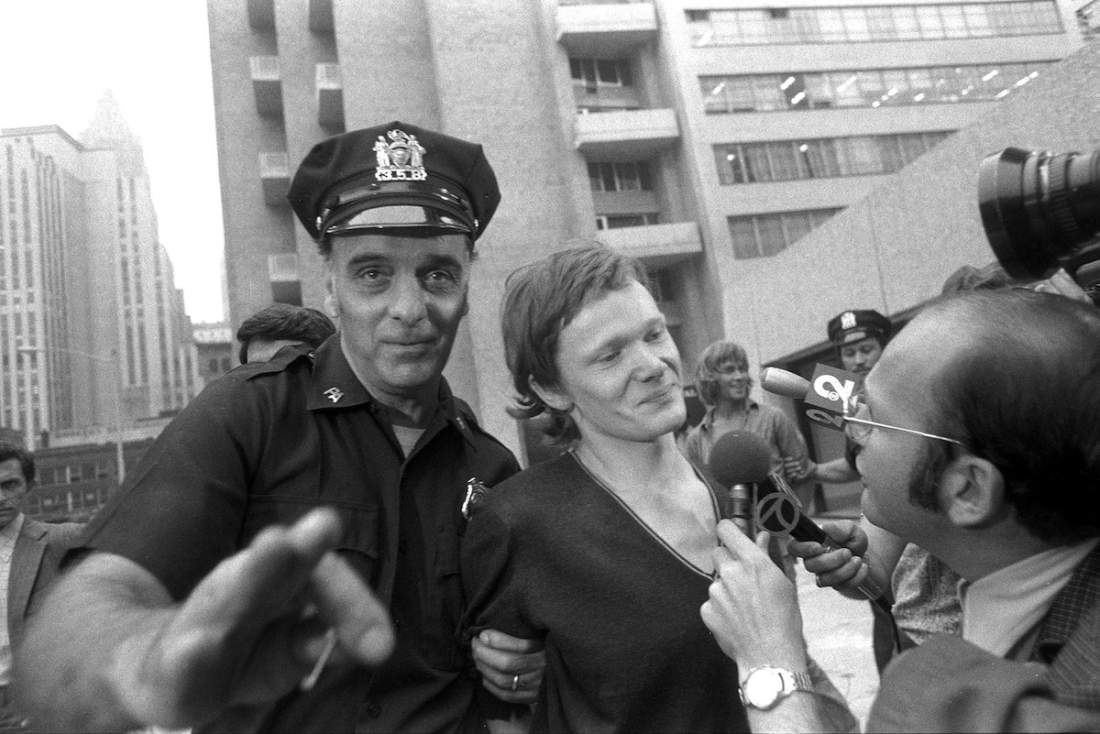 New York Daily News Archive / Getty ImagesPhilippe Petit (center) answers reporter's questions on Aug. 7, 1974, as he is escorted from Beekman Hospital by Port Authority police officer in New York City. Petit was arrested after he walked a tightrope between the two towers of the World Trade Center.