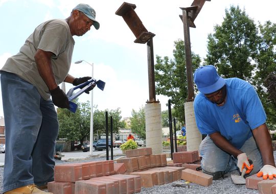 From left, Tomas Marcial, 60, and Jimmy Floyd, 67, lay bricks for Poughkeepsie City Hall's September 11th memorial on Tuesday.  (Photo: Patrick Oehler/Poughkeepsie Journal)