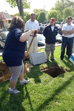 Marty Aponte, John Feal, Glen Klein and others look on as a relative of one of the fallen helps bury a time capsule Saturday at the 9/11 Responders Remembered Park. Photo by Lorene Eriksen