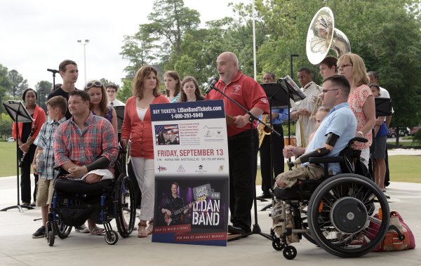 John Masson, center, announces in May the events to raise funds to build 'smart homes' for Army Master Sgt. John Masson, left, and Marine Staff Sgt. Thomas McRae. Staff photo by Marcus Castro