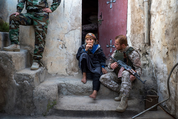 A member of a Christian militia unit tries to persuade Kamala Karim Shaya, one of the last residents of Telskuf, to move to a secured home near their barracks. Credit Peter van Agtmael/Magnum, for The New York Times