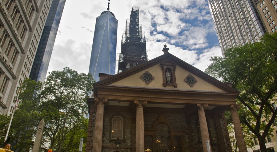 The World Trade Center looms behind St. Paul's Chapel with its steeple wrapped in scaffolding for repairs, Thursday, June 25, 2015 Photo Bebeto Matthews, AP