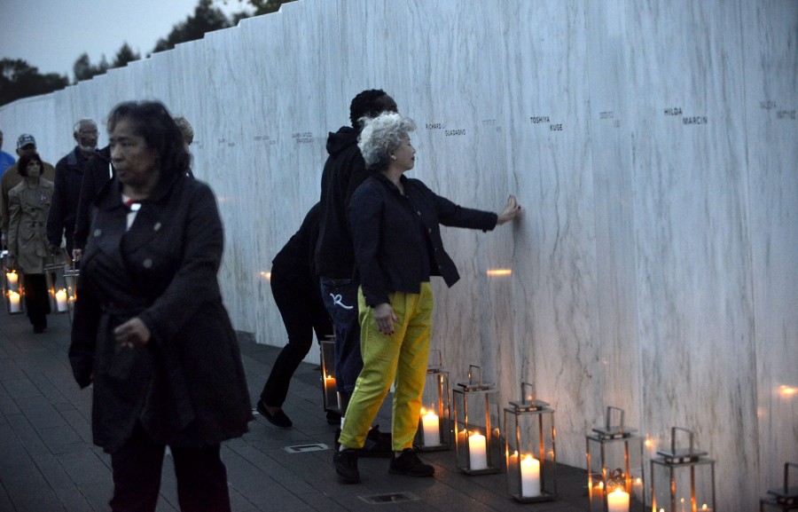 Family members and friends linger Wednesday evening after carrying in luminaries to the victims' wall at the Flight 93 National Memorial. Larry Roberts/Post-Gazette