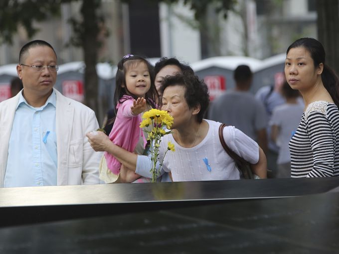 Family members of Ji Yao Justin Zhao, who was killed at the World Trade Center on September 11, 2001, pay their respects during a ceremony in New York. Pool photo by Mary Altaffer