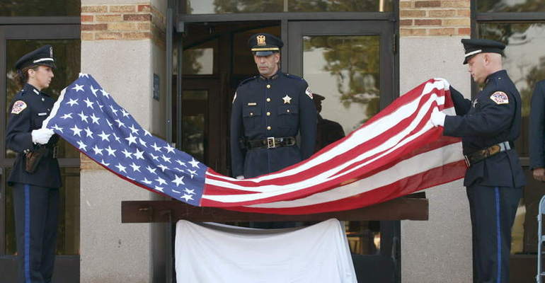 During a ceremony marking the 10th anniversary of the 9/11 terrorist attacks, Park Ridge police officers place a flag over a steel beam from the World Trade Center. File photo