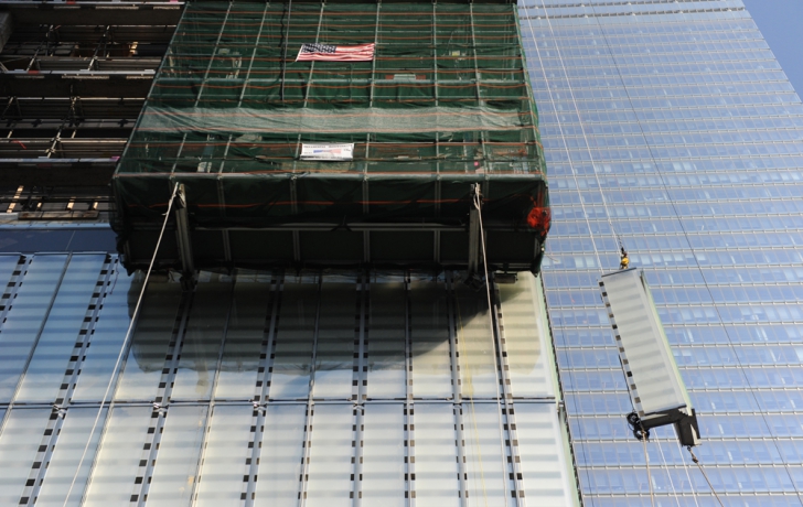 A two-pane panel of glass is hoisted to a corner section of the 1 World Trade Center podium. Carl Glassman, Tribeca Trib