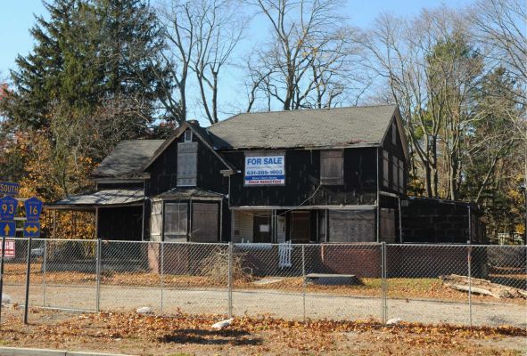 A boarded-up house at 516   Gibbs Pond Rd. in Nesconset is across the street from a September 11 memorial. The house will be knocked down, and a 7-Eleven will be built there. (Nov. 19, 2013) Photo: James Carbone