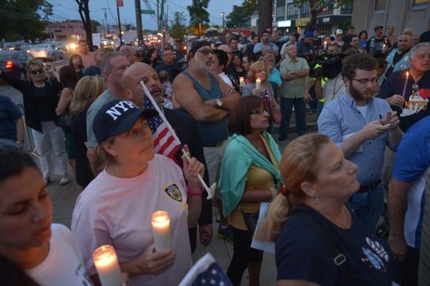 People hold candles during a community vigil in front of the 122 Precinct stationhouse to remember the 813 NYPD officers killed in the line of duty.(Staten Island Advance/Bill Lyons)