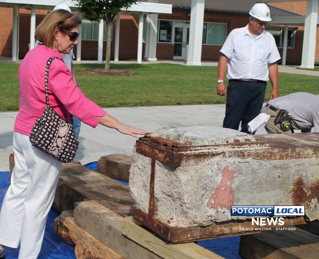 Supervisor Maureen Caddigan touches of the steel beams that once made up the World Trade Center. After the beams were brought to Prince William County from New Jersey in 2010, Caddigan worked to bring then out into the public and to preserve them for use in a permanent memorial. [Uriah Kiser / Potomac Local News]